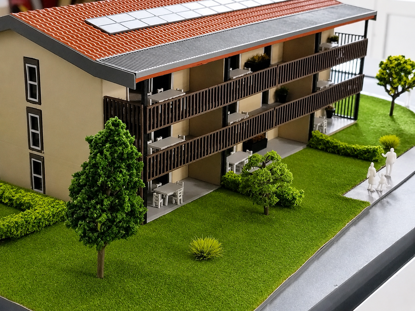 Détail de maquette architecturale d’un bâtiment résidentiel avec balcons, panneaux solaires et espaces verts