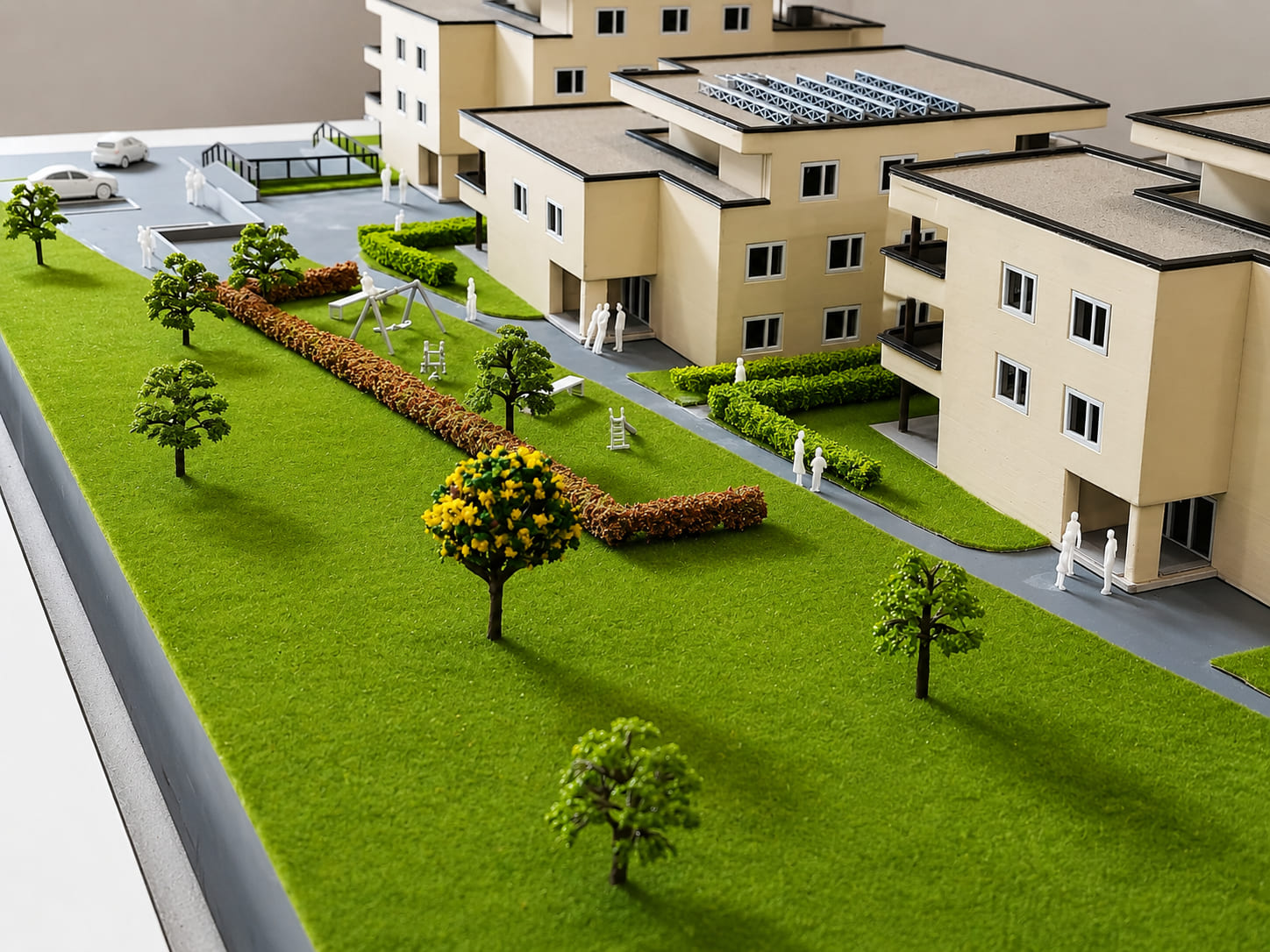 Détail d’une maquette immobilière résidentielle avec bâtiments, jardins, arbres et espaces verts